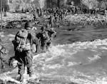 U.S. reinforcements wade through the surf as they land at Normandy in the days following the Allies' June 1944 D-Day invasion of occupied France.