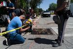 Joseph Avila, left, prays while holding flowers honoring the victims killed in Tuesday's shooting at Robb Elementary School in Uvalde, Texas, Wednesday, May 25, 2022. Desperation turned to heart-wrenching sorrow for families of grade schoolers killed after an 18-year-old gunman barricaded himself in their Texas classroom and began shooting, killing at least 19 fourth-graders and their two teachers.