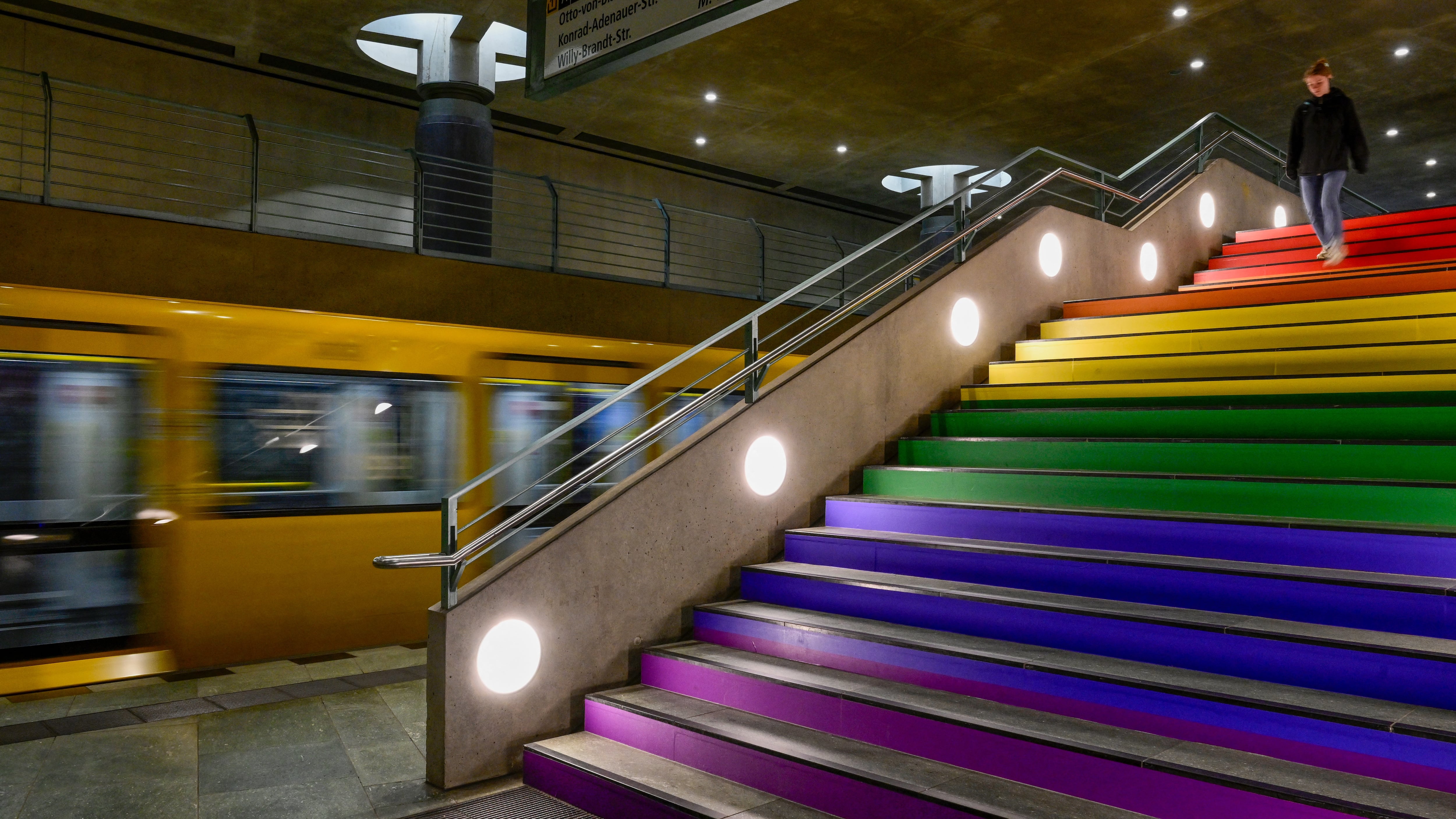 A commuter walks down the steps of Berlin's Bundestag subway station, decorated with rainbow colors, the symbol of the LGBTQ+ community, on July 24.