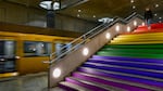 A commuter walks down the steps of Berlin's Bundestag subway station, decorated with rainbow colors, the symbol of the LGBTQ+ community, on July 24.