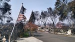 A partially burned American flag flutters in the breeze in front of the remains of a mobile home in Talent, Ore., on Thursday, Sept. 10, 2020. The town estimates it would cost $14 million to fund 16 urban renewal projects. A recently voted down tax increment financing district means the town will now have to rely on competitive grant funding. 