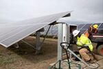 Electricians Ryan Lichty, left, of Silverton, and David Hammang, of Dayton, work on the Cypress Creek Renewables solar energy farm under construction just outside Silverton, Ore., on Tuesday, Oct. 17, 2017.