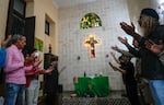 Same-sex couples stand in prayer with outstretched hands inside the Metropolitan Community Church, an LGBTQ+ inclusive house of worship, in Matanzas, Cuba, Friday, Feb. 2, 2024. Cuba repressed gay people after its 1959 revolution led by Fidel Castro and sent many to labor camps.