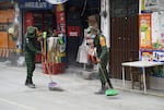 Mexican soldiers sweep ashes from the streets Tuesday in Santiago Xalitzintla.