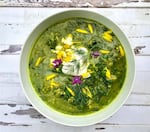 Green soup with herbs and flowers.