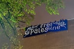 FILE: A large sign is unfurled from the roof of the building while spectators cheer, as the occupation continued at Portland State University’s Branford Price Millar Library, May 1, 2024. 