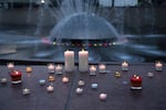 Lit candles line the International Fountain during a community vigil in honor of the three people who were shot and killed during Bite of Seattle the previous day, on Monday, July 27, 2026, at Seattle Center.