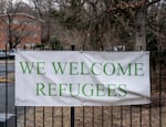 A sign that reads "we welcome refugees" hung on the gates of the Parkview Apartments located in Riverdale, Md.