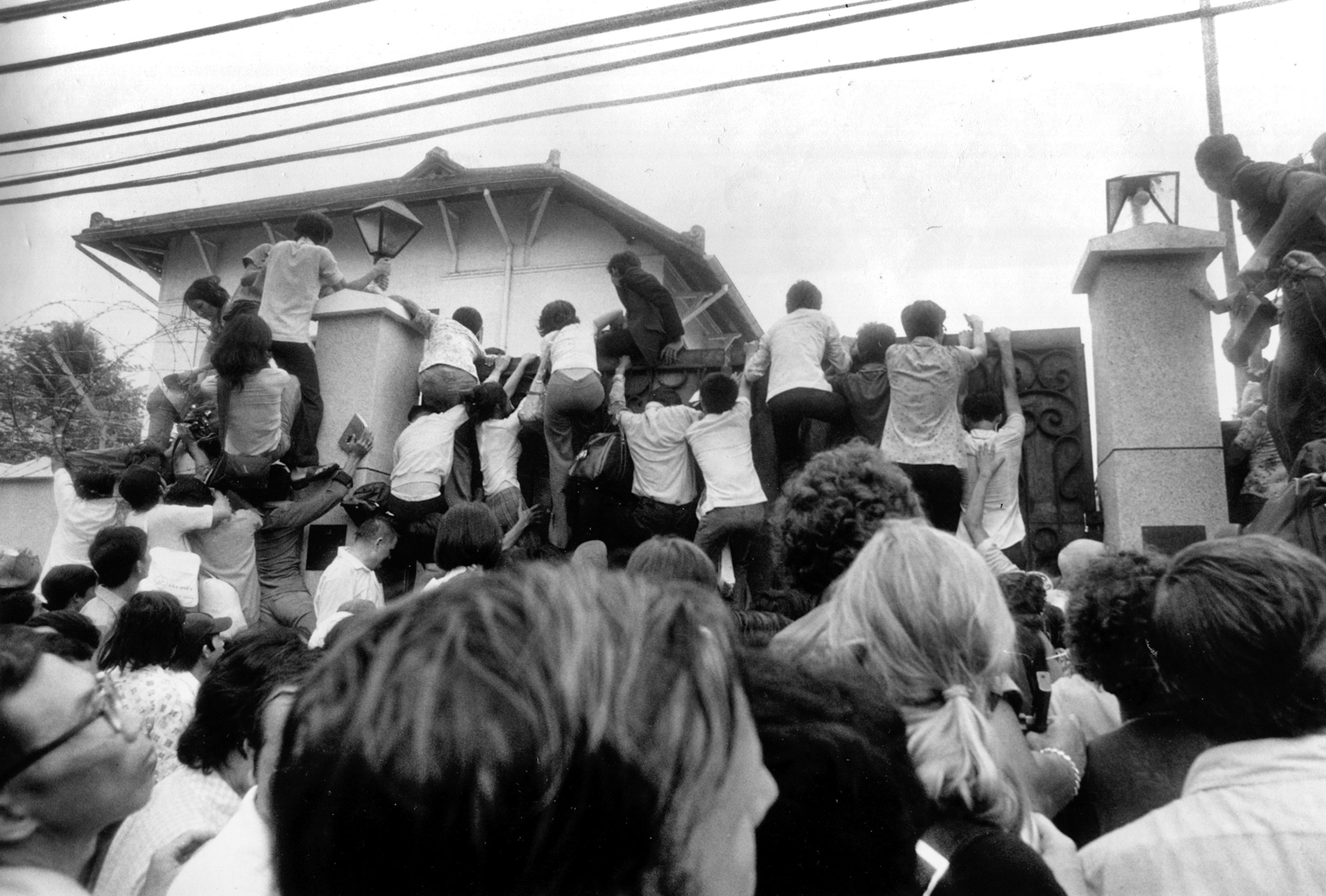 South Vietnamese civilians try to scale the walls of the U.S. Embassy in Saigon in an attempt to get aboard evacuation flights on April 30, 1975.