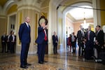 Senate Majority Leader John Thune, R-S.D., watches as President Trump speaks to the media as they arrive at the Capitol on Wednesday.