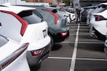 People look at vehicles at the Beaverton Kia dealership, with electric vehicles at left, on Wednesday, April 15, 2026, in Beaverton, Ore. (AP Photo/Jenny Kane)
