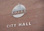 A sign on a brick wall says Boise City Hall.