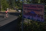 A biker rides past a sign that reads “Change Camas Form of Government?” on Monday, Aug. 17, 2026, in Camas, Wash.
