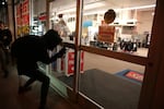 A protester spray paints a storefront during a third night of post-election demonstrations in Portland on Nov. 10, 2016.