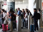 Travelers await rides at Los Angeles International Airport ahead of the Labor Day holiday on Friday.