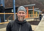 Jacob Fox, executive director of Homes for Good, stands in front of a line of brand new modular homes in the newly rebuilt Lazy Days Community.