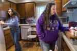 Ashley Mahan, right, looks over her medications at her Corvallis home, Aug. 12, 2022, as her daughter Marina Bermudez, 14, looks on. "The only way I can semi-function," Mahan said, "is with five medications or more."