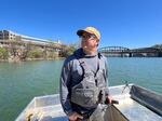 Evan Clark steers a boat on the Monongahela River, one of two tributaries that converge to form the Ohio River in Pittsburgh, PA. Clark works with Three Rivers Waterkeeper, an environmental nonprofit that works to protect the rivers.