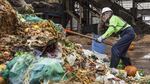 Zdenka Novak, a Recology employee contracted by Metro, pulls unacceptable plastic and cardboard out of the commercial food waste piles at the Metro Central transfer station.