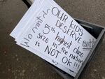 FILE - Extra signs sit to the side of a Salem-Keizer Education Association rally at the district's administrative offices in Northeast Salem on Dec. 19, 2023.