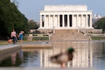With a blue sky above the Lincoln Memorial, people walk along the reflection pool in Washington, D.C., on June 9, 2023.