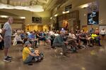 Attendees watch the Flat Fire community meeting on one of three monitors in an overflow area of the Sisters High School in Sisters Ore., on Aug. 25, 2025.