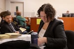 Defense attorney Stacey Reding looks over documents during a court hearing Tuesday, Oct. 8, 2019, at the Multnomah County Justice Center in Portland, Ore. Reding said it's frustrating to be unable to provide clients in need of mental health treatment everything they need.