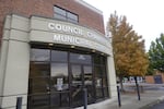 The end of a red brick building has two signs above its door reading "Council Chambers" and "Municipal Court."