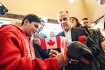 Canada's Prime Minister Mark Carney signs an autograph as he attends a national unity rally in Red Deer, Alberta, Oct. 16.