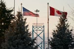 Canadian and American flags fly on the Canadian side of the Ambassador Bridge in Windsor, Ontario, on March 8. President Trump imposed vast tariffs this week on key partners Canada and Mexico, roiling cross-border ties before offering temporary relief to manufacturers -- but with more levies kicking in next week, the respite may be fleeting.
