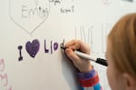 A child writes a message on the wall of the Lloyd Center.