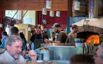 Chef Vincent Krone, center, of Ken’s Artisan Pizza in Portland, Ore. prepares orders in an open kitchen, Aug. 9, 2024. Krone has been with Ken’s Artisan Pizza for six years.