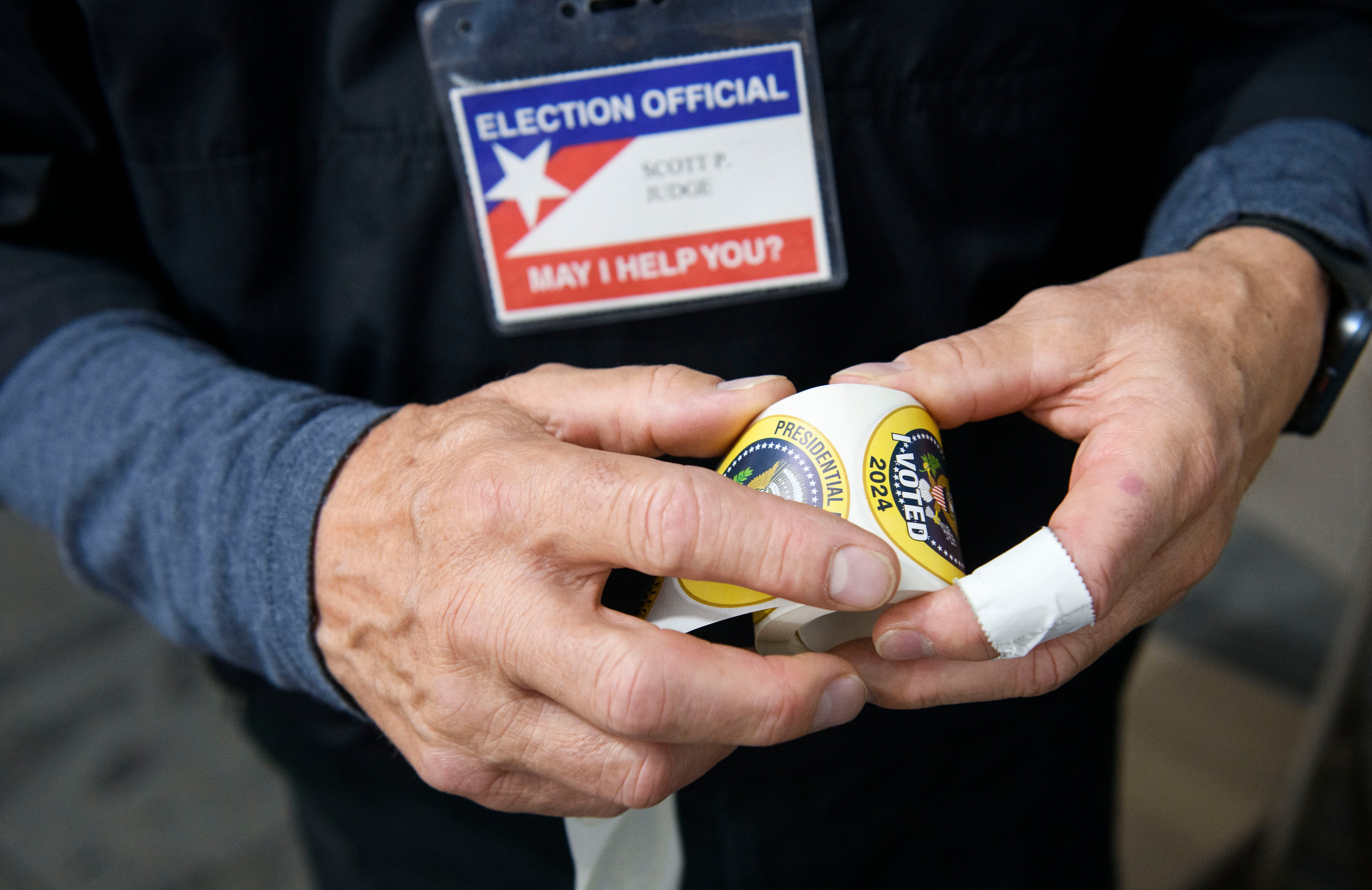In this file photo, a poll worker rolls up stickers while working inside a FEMA tent used as a voting site on November 5, 2024 in Morganton, North Carolina.