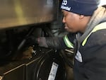 Trevor Bennett with Sequential Biofuels cleans out a grease trap at a brewery kitchen in Northeast Portland.