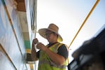 Alex Chiu paints a small portion of his mural on NE 82nd Ave.