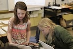 Dude, right, works with a classmate on a writing exercise in late March. In addition to reading, writing and math, schools are trying to familiarize kids with technology.