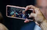 President Joe Biden holds a phone and takes a selfie of himself with attendees, following his appearance at East Portland Community Center in Portland, Oct. 15, 2022.