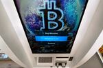 FILE - In this Feb. 9, 2021, file photo, the Bitcoin logo appears on the display screen of a cryptocurrency ATM at the Smoker's Choice store in Salem, N.H. China’s central bank on Friday, Sept. 24, 2021, declared all transactions involving Bitcoin and other virtual currencies illegal, stepping up a campaign to block use of unofficial digital money.