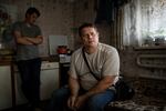 Rodion Lebedev with his son, Dmitry, in their home in Opytne, a suburb of Donetsk, Ukraine, in July 2018. The family was living in a backyard shed, normally used as a second kitchen, at the time, as the house was heavily damaged by shelling. Around 2021, the Lebedevs managed to rebuild their house — only to have it destroyed again a year later.