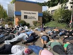 About 75 people laid on the ground in front of PeaceHealth Medical Center University District as part of a "die-in" demonstration in protest of plans to close Eugene's only hospital on Oct. 13, 2023.