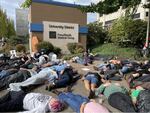 About 75 people laid on the ground in front of PeaceHealth Medical Center University District as part of a "die-in" demonstration in protest of plans to close Eugene's only hospital on Oct. 13, 2023.