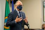 A man in a mask speaks to an audience.