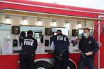 Firefighters use a hand-washing station with socially distanced sinks at a training event in June, 2020.