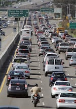 FILE - In this May 26, 2011 file photo, a motorcyclist rides between lanes in California.