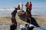 Zade Futch, 12-year-old citizen of the Coquille Indian Tribe, stands in his cedar woven hat with three other young Coquille citizens. The young boys play on the beach following the Coquille Indian Tribe's 35th Annual First Salmon Ceremony on June 28, 2024.