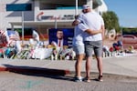 People embrace in front of a memorial for Charlie Kirk at the Turning Point USA headquarters on September 12, 2025 in Phoenix. Kirk, the CEO and co-founder of Turning Point USA, was shot and killed on Wednesday in Utah. (Photo by Eric Thayer/Getty Images)