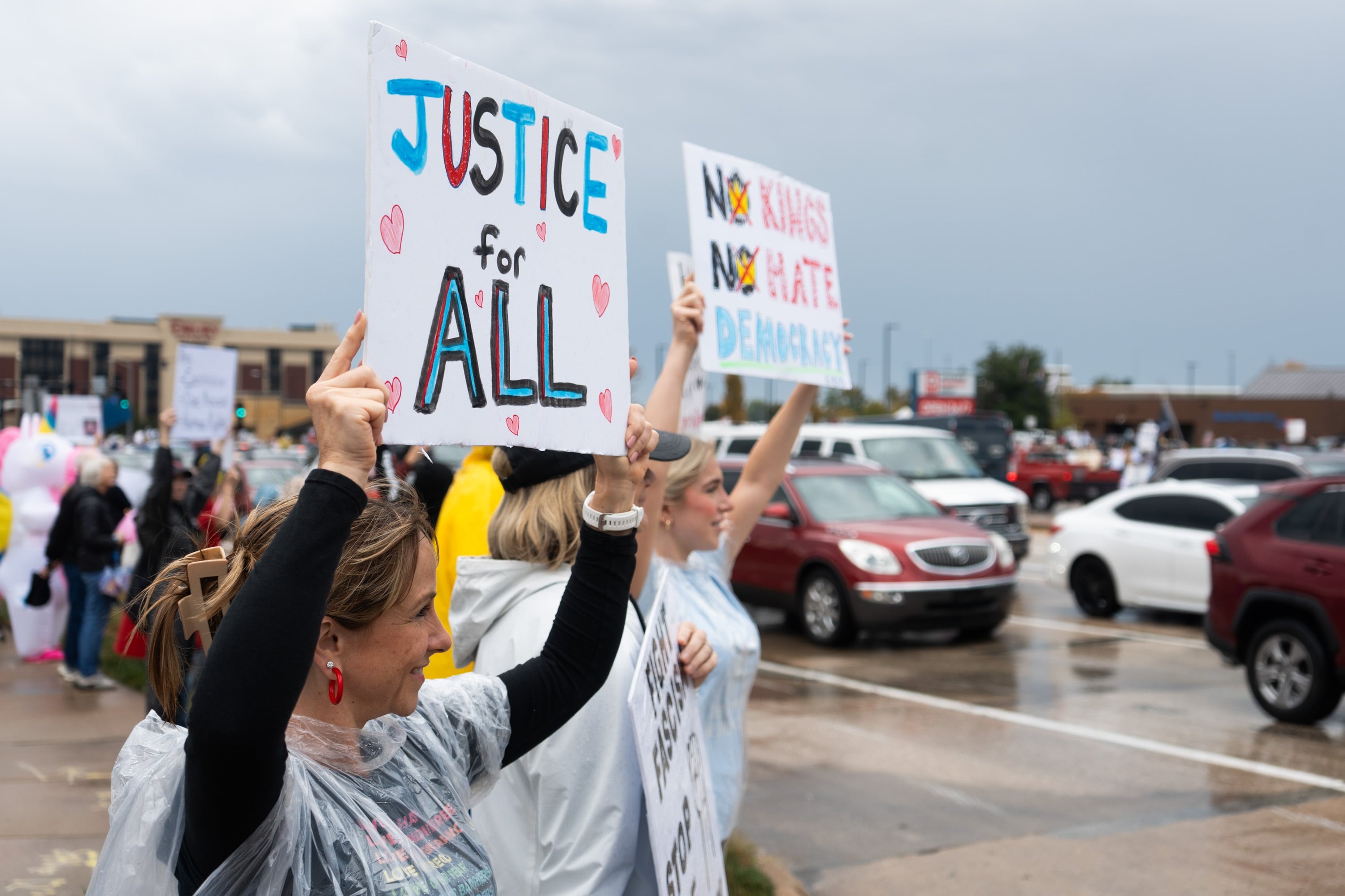 Amy Gryder (l) and her daughter, Ella Walther (r), stand outside for the No Kings Protest on Mid Rivers Mall Drive in St. Peter's, MO. Walther says when it comes to civil liberties that goes for everybody.