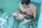 Amir Tal holds his newborn baby girl in a conversion ceremony in Portland, Oregon.