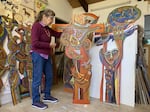 Artist Betty LaDuke in her Ashland studio with some of her wood panel pieces.