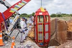 Rescue workers look on as a cage is lifted from an abandoned gold shaft in Stilfontein on January 16, 2025. 